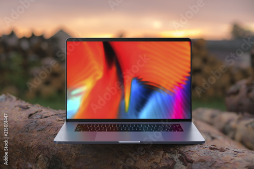 A laptop with a colorful screen on wooden beams. Laptop in focus. High detailed. photo