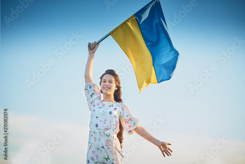 Child carries fluttering blue and yellow flag of Ukraine in field. Ukraine's Independence Day. Flag Day