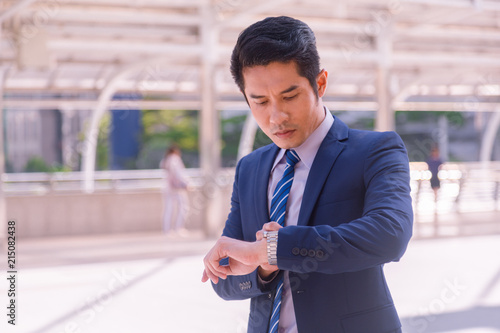 Business man seeing wristwatch to check time at office.annual and summary report.It's Time out for appointment meeting.Time out concept