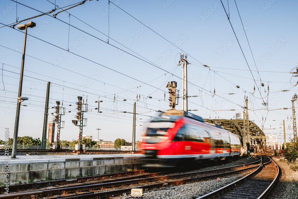 Fototapeta premium Pociąg jedzie do dworca kolejowego w Kolonii