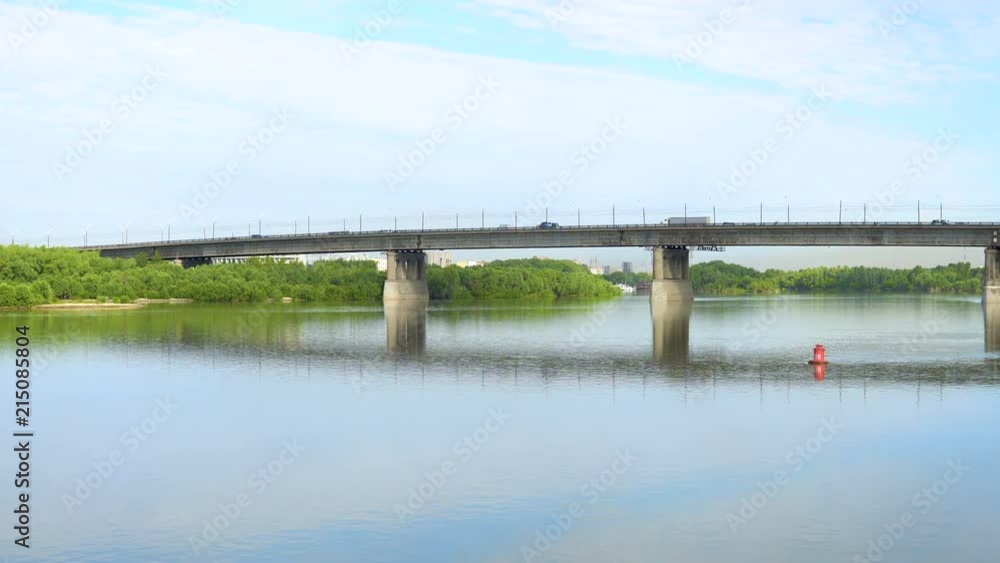 Cars and trucks drive through the city bridge. View from afar.