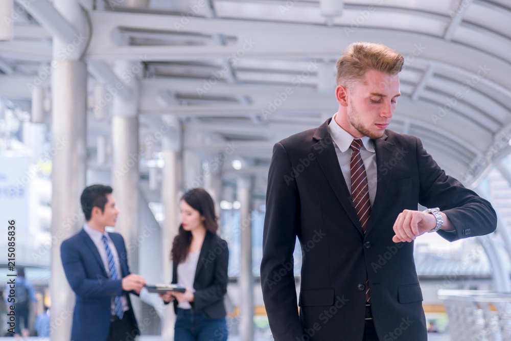 Business man seeing wristwatch to check time at office.annual and summary report.It's Time out for appointment meeting.Time out concept