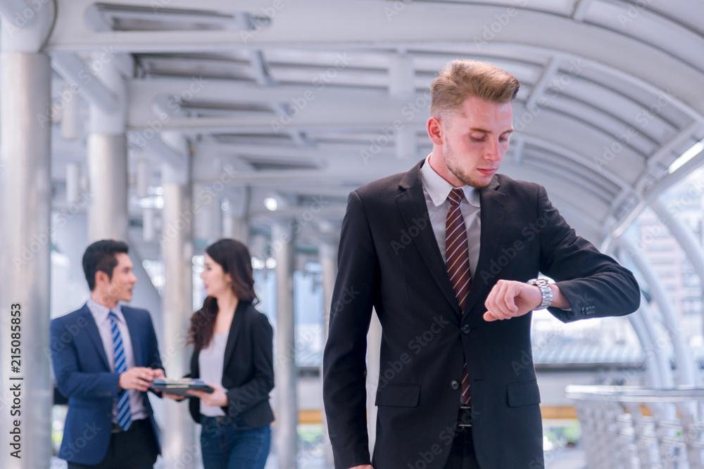 Business man seeing wristwatch to check time at office.annual and summary report.It's Time out for appointment meeting.Time out concept Business man seeing wristwatch to check time at office.annual and summary report.It's Time out for appointment meeting.Time out concept