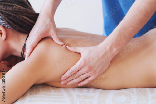 Close-up of masseur hands doing back massage - Healing Massage and body care - young woman getting spa massage treatment at beauty spa salon