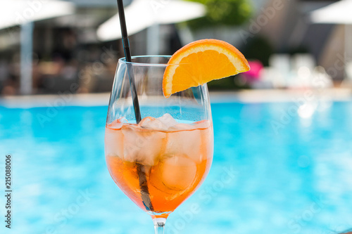 Cold glass of aperol sprit on a pool background