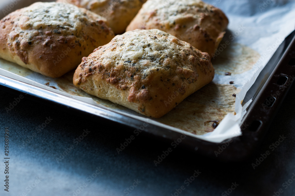 Obraz premium Freshly Baked Square Garlic Bread with Cheese and Herbs in Oven Tray.