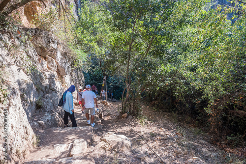 Unidentified people going down to stone slippery stairs towards cave of Chasm of Heaven in Silifke district, Mersin Turkey.29 August 2017..