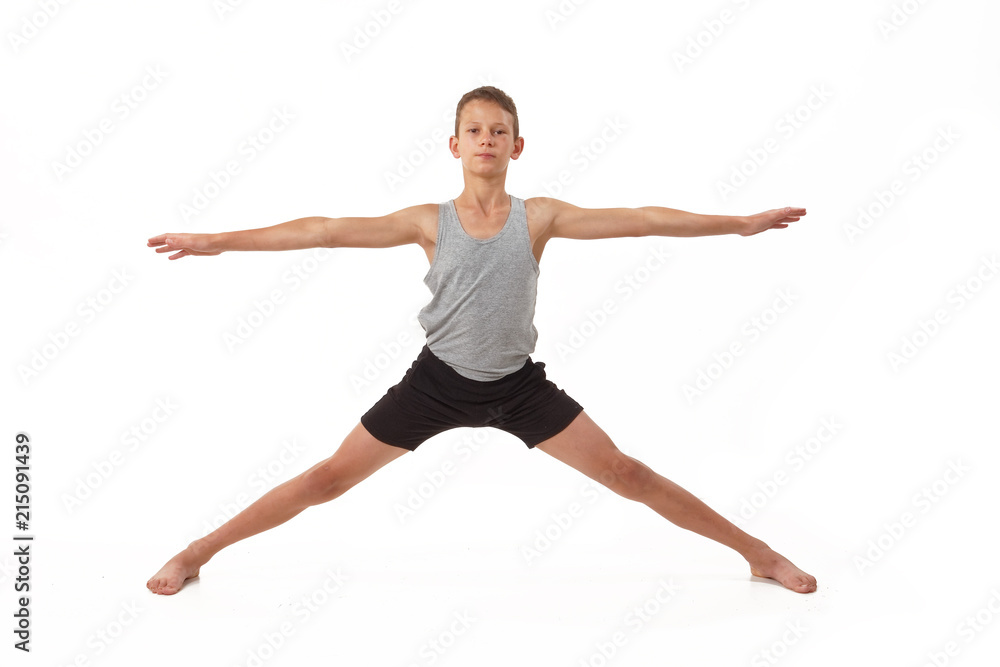 Teen in a T-shirt and shorts performs gymnastic exercises.