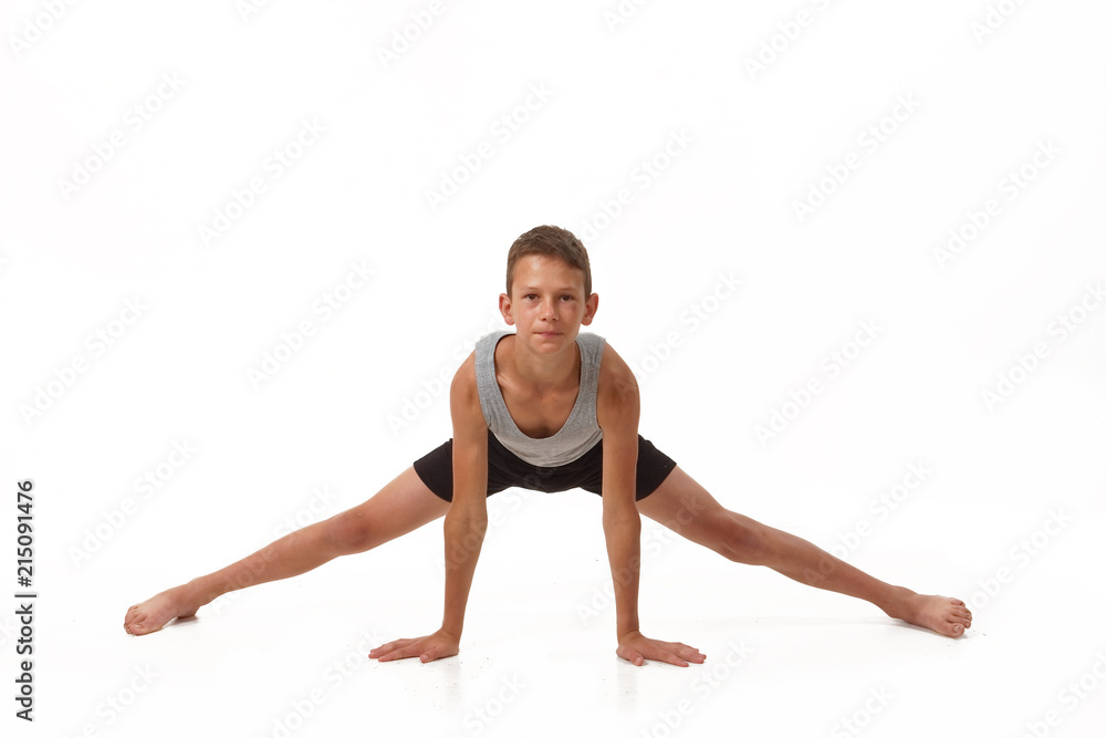 Teen in a T-shirt and shorts performs gymnastic exercises. Teen in a T-shirt and shorts performs gymnastic exercises.