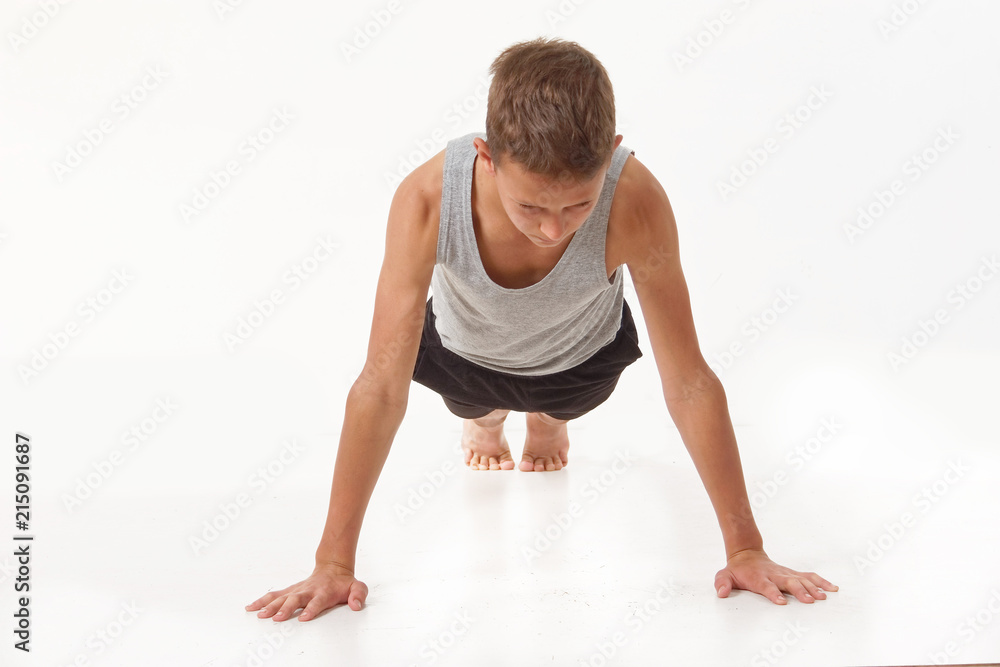 Fototapeta premium Teen in a T-shirt and shorts performs gymnastic exercises.