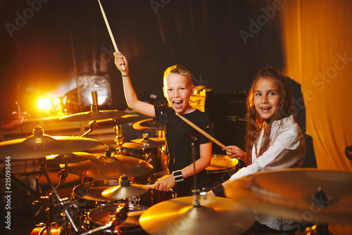 Fototapeta boy and girl play drums in recording studio