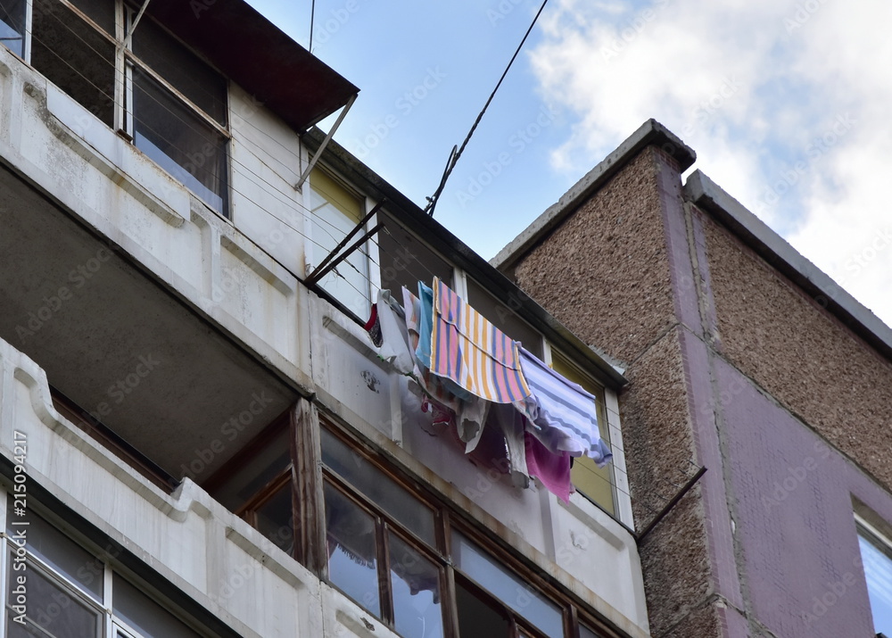 On the balcony of the old apartment house, dry linen: towels, blankets, sheets