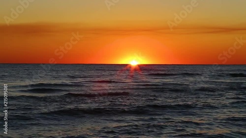 Sun completely disappears past the ocean's horizon. photo