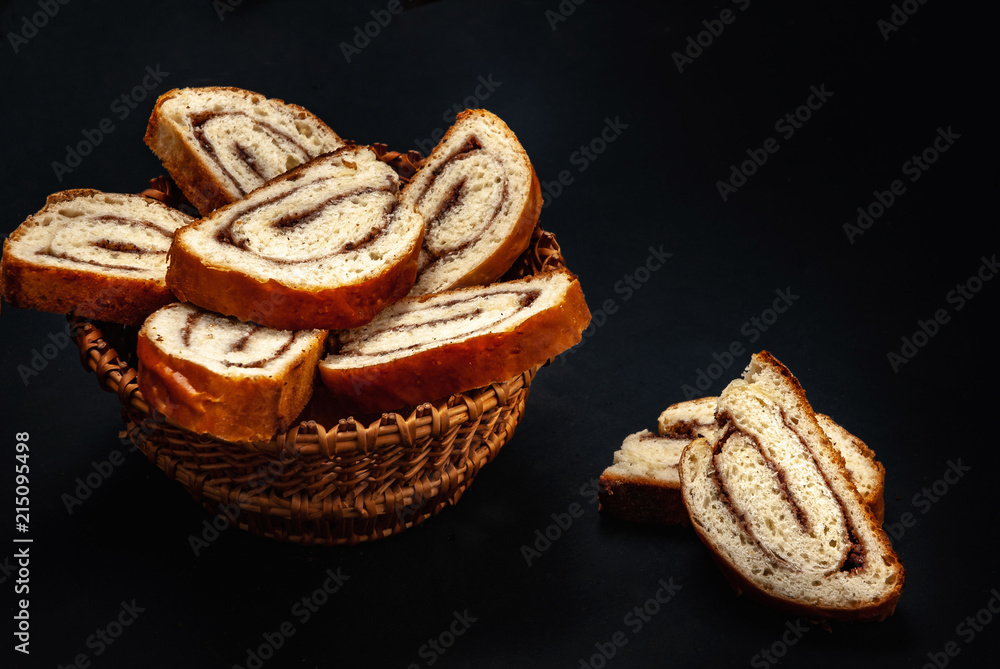 fresh appetizing strudel with cinnamon, sliced on a black background