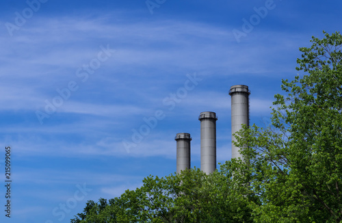 Modern Smokestacks behind Trees Blue Sky Berlin Germany
