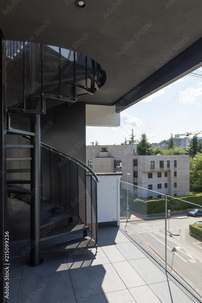 Fototapeta premium External spiral staircase in the private apartment on the top floor, nobody