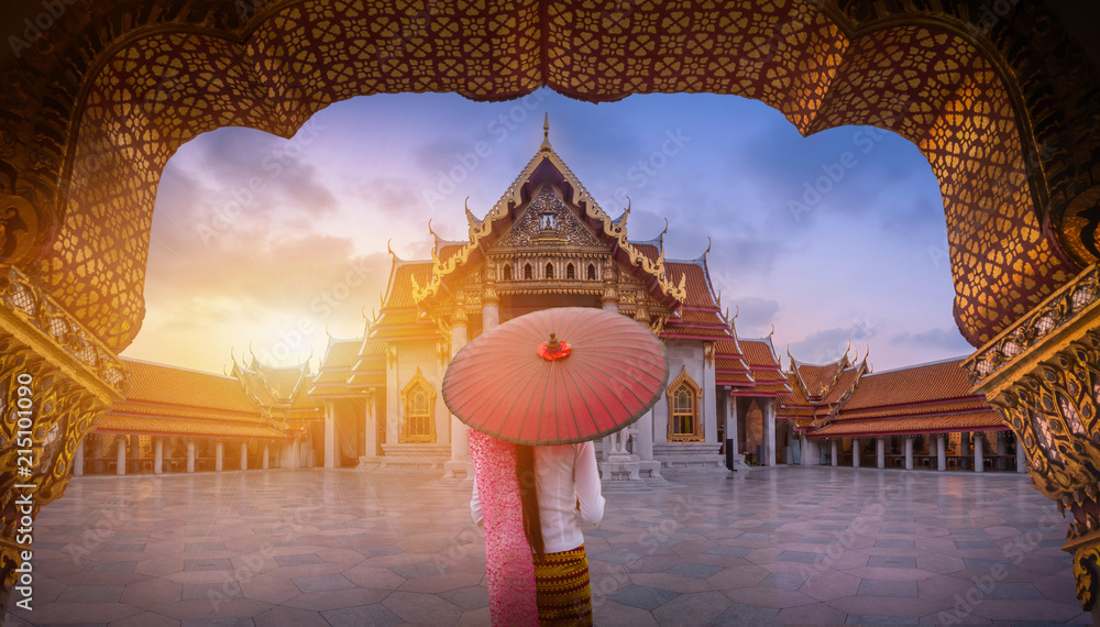 Woman with red umbrella at entrance of Marble Temple, Bangkok - obrazy, fototapety, plakaty 