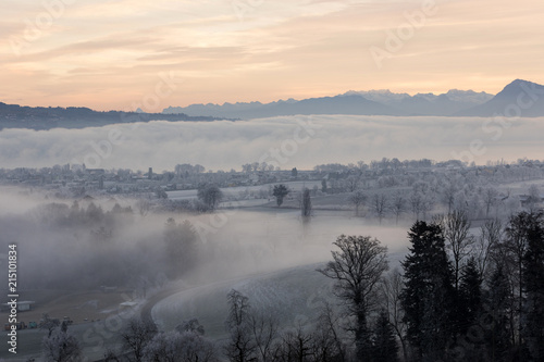 Fototapeta Naklejka Na Ścianę i Meble -  Ice cold winter morning with fog and Mount Rigi in the background during the dawn in Central Switzerland