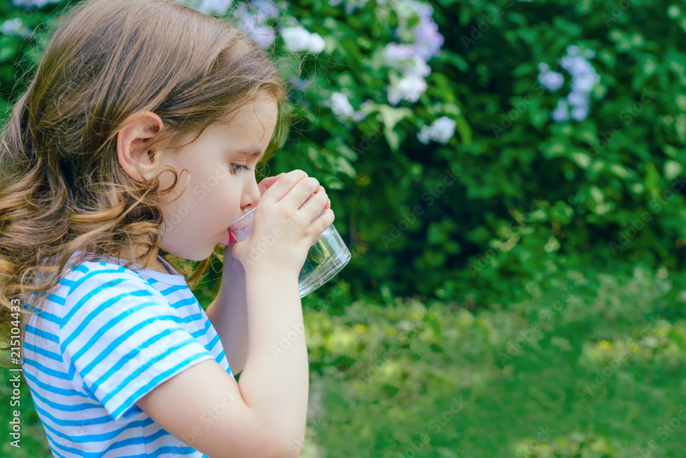 child drinks water on a Sunny summer day. selective focus. child drinks water on a Sunny summer day. selective focus.