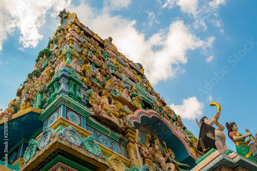 A low angle view of Sri Layan Sithi Vinayagar Hinduism Temple in Singapore. Colorful Indian deities on the sky background. photo