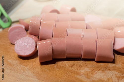 Sliced sausage rings on the wooden table photo