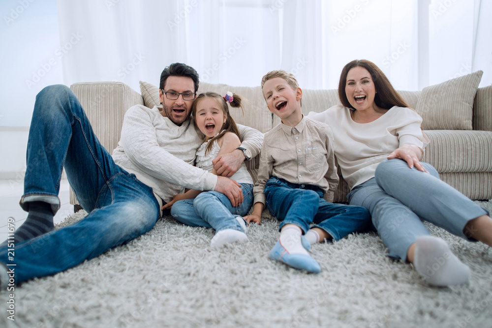 happy family sitting on the carpet in the living room. happy family sitting on the carpet in the living room.