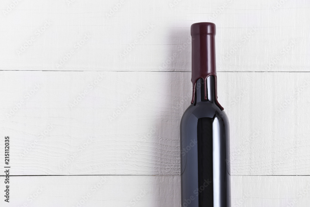 Single Bottle of Wine on a White Wood Table. The thin bottle has a wax seal  over the top. Stock Photo | Adobe Stock