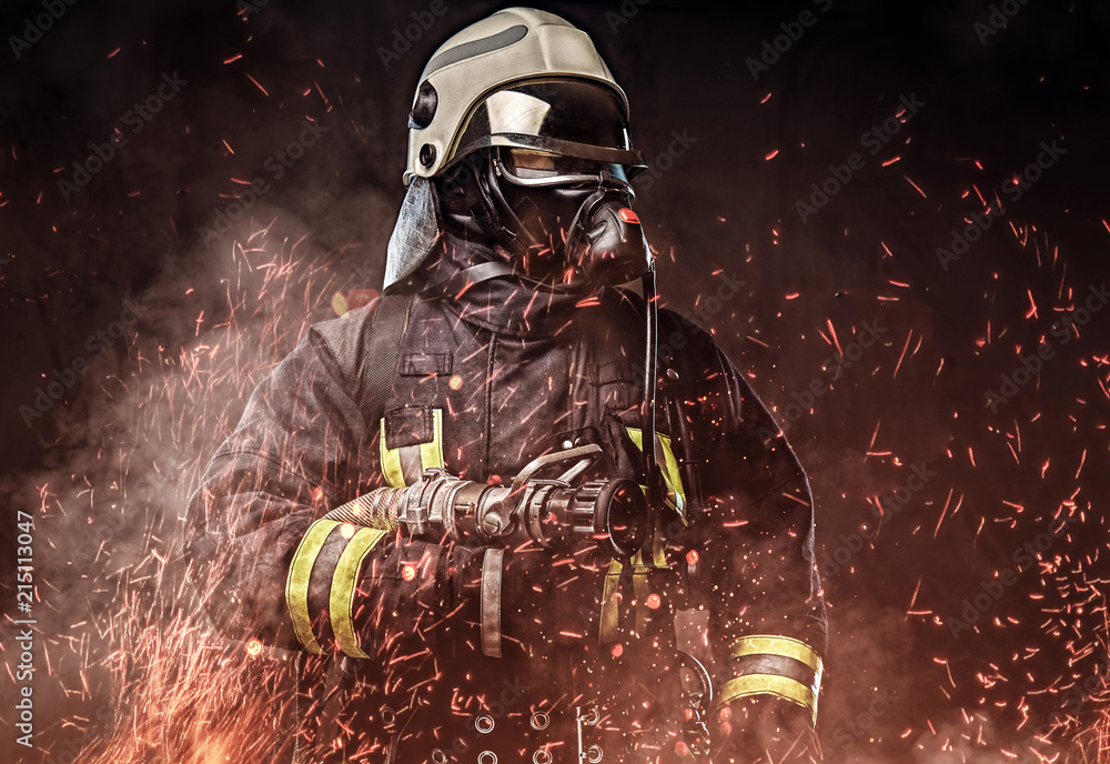 Fotografering, Billede A firefighter dressed in a uniform in a studio. på  Europosters.dk