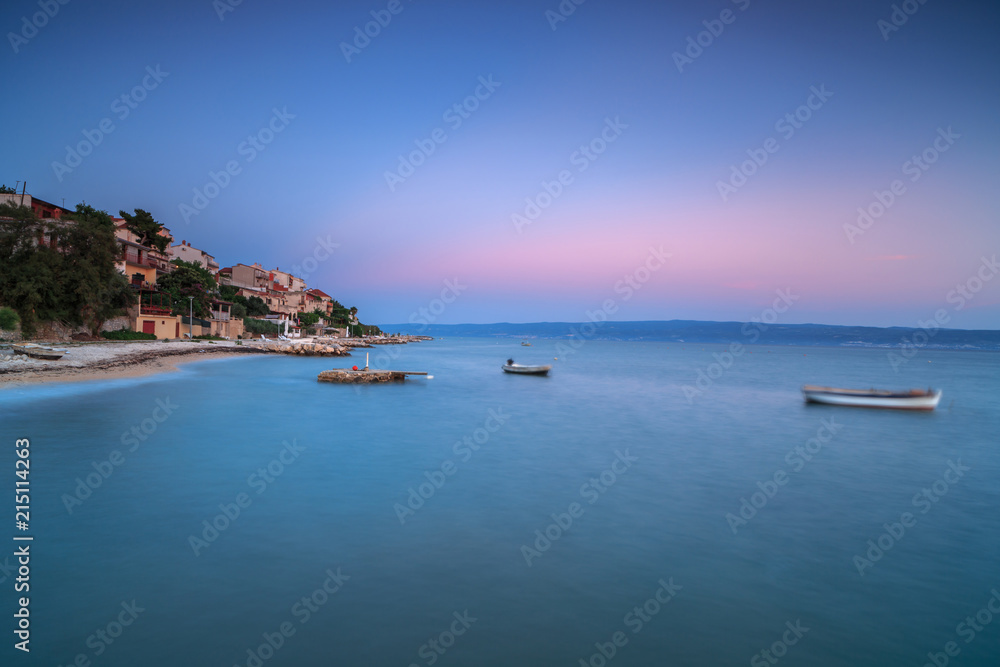 Coastline view with moving boats in Adriatic sea at sunset,long exposure