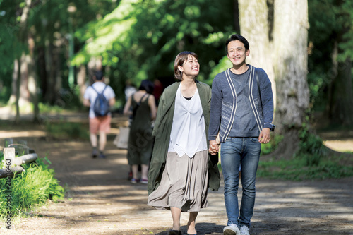 デートで新緑の爽やかな小道を散歩するカップル