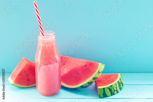 Watermelon slices and juice on a turquoise background