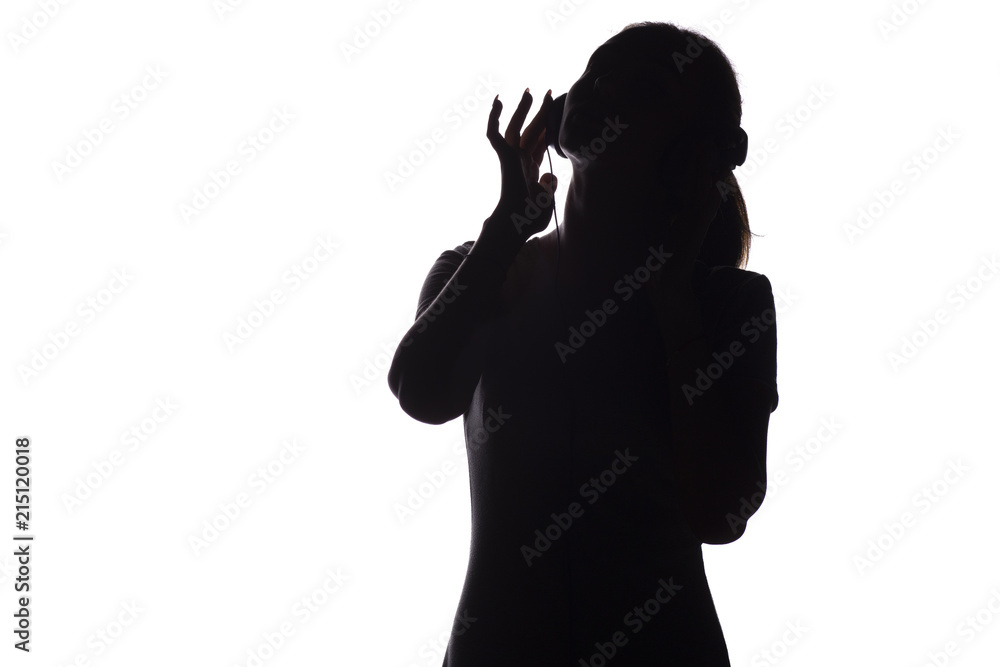 silhouette of a girl listening to music in headphones on a white isolated background