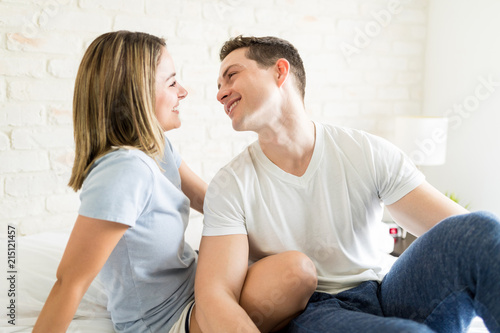 Man Looking At Woman With Love While Sitting On Bed