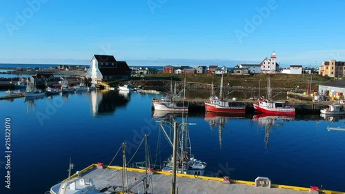 Beautiful drone footage of calm ocean water and colourful fishing boats in Bonavista, NL Canada photo