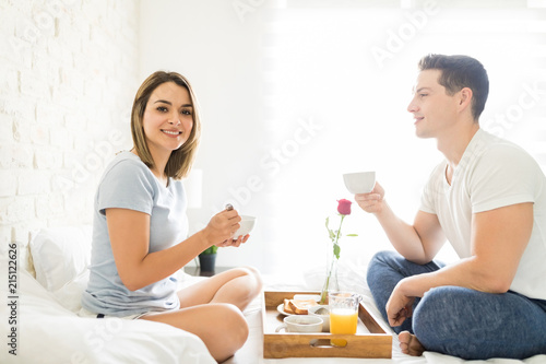 Woman Smiling While Having Breakfast With Boyfriend On Bed