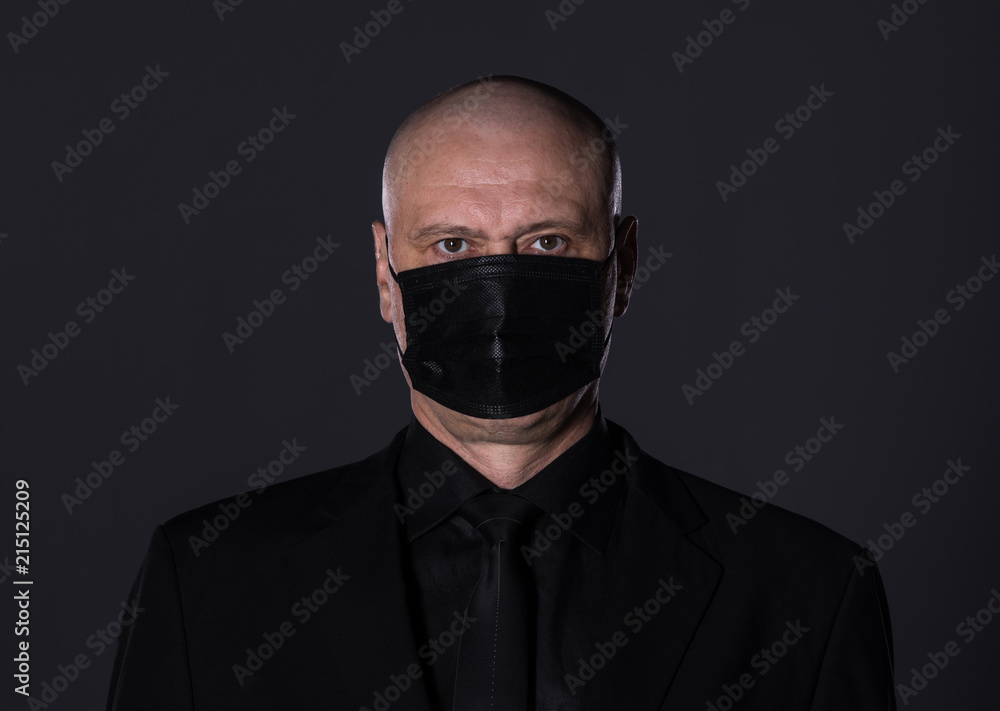 studio portrait of a 50 year old man in black clothes on a black background