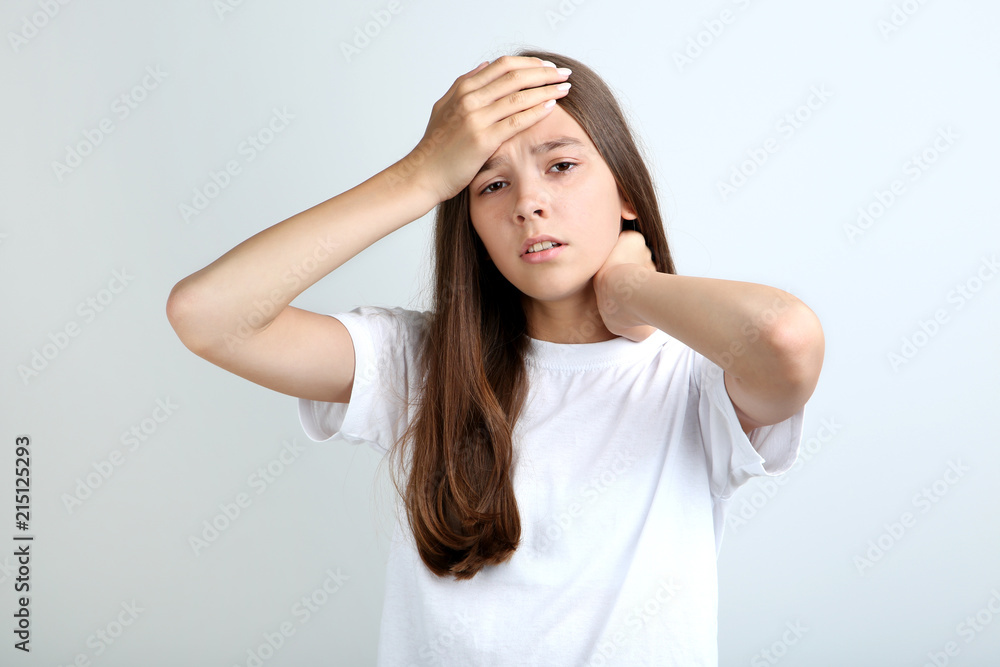 Young girl having headache on grey background Young girl having headache on grey background