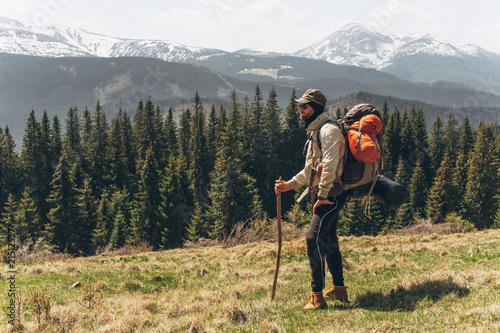 A man stands on the top and admires the mountains