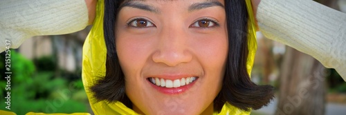 Composite image of woman wearing yellow raincoat against white