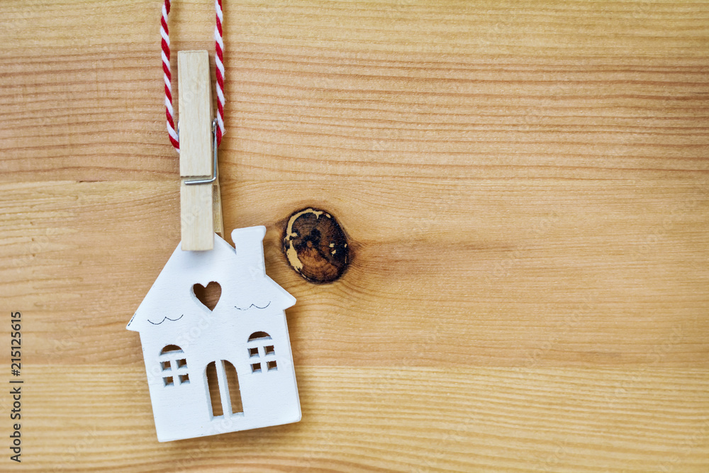 Small White House Model Hanging On Wooden Background Small White House Model Hanging On Wooden Background