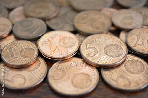 Euro cent coins. 1 euro, 2 euro and 5 euro cent coins on wood table.