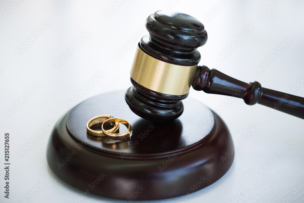 Close up of Judge gavel deciding on marriage divorce and two golden marriage ring Close up of Judge gavel deciding on marriage divorce and two golden marriage ring