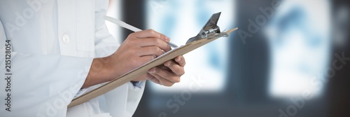 Composite image of doctor writing on clipboard against white photo