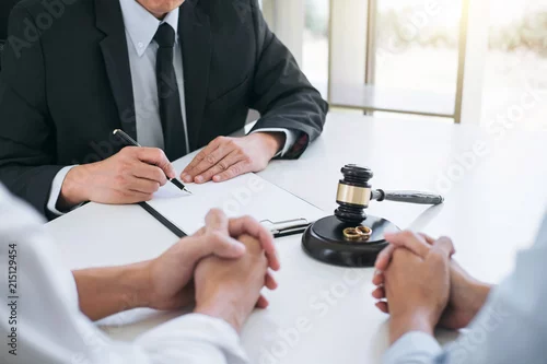 Obraz Agreement prepared by lawyer signing decree of divorce (dissolution or cancellation) of marriage, husband and wife during divorce process with male lawyer or counselor and signing of divorce contract