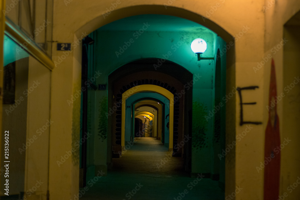 soft focus night arch backstreet urban scene with colorful yellow and green lamp illumination