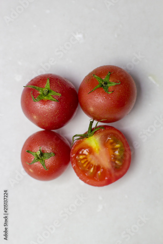 Fresh tomatoes on white background. Top view. With splashes of water.
