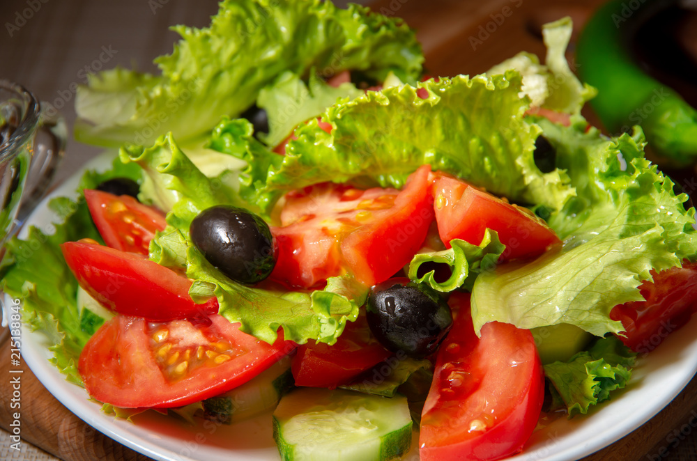 Salad of tomatoes, olives and cucumbers with olive oil