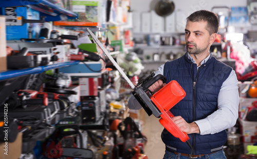Cheerful man is buying new electric saw