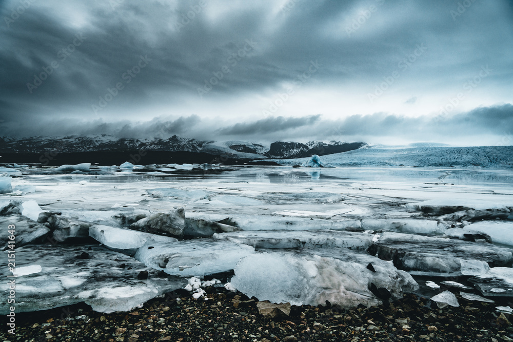 Obraz premium Fjallsarlon Jokulsarlon Huge glacier and mountains in Iceland Vatnajokull glacier aerial drone image with clouds and blue sky. Dramatic winter scene of Vatnajokull National Park, Iceland, Europe