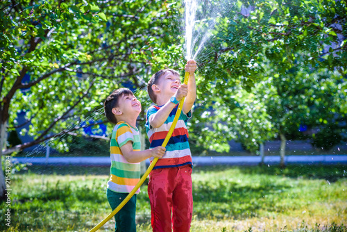 Brothers having fun splash each other with water in the village